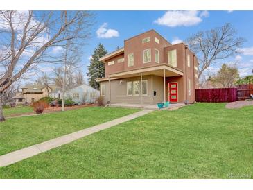 Modern home with a manicured lawn, unique architecture, and a vibrant red front door at 2624 S Race St, Denver, CO 80210