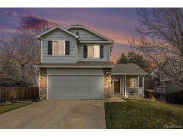 Charming two-story home featuring a two-car garage, inviting porch, and well-maintained lawn at 23813 Broadmoor Dr, Parker, CO 80138