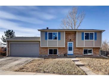 Charming two-story home with brick accents, blue shutters and attached garage, offering classic curb appeal at 14798 E Temple Dr, Aurora, CO 80015