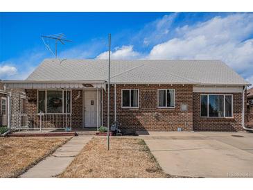 Charming brick single-story home with manicured lawn and cozy covered porch in a residential neighborhood at 865 S Dale Ct, Denver, CO 80219