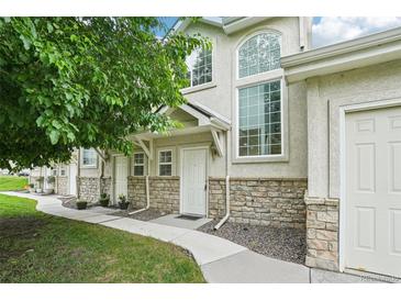 Charming townhome with stone accents, lush landscaping, and multiple windows at 2253 Coronado Pkyn # D, Denver, CO 80229