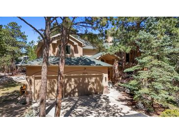 Two-story home featuring a three-car garage with lovely mature trees surrounding the property at 20050 Lost Arrowhead Dr, Monument, CO 80132