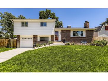 Inviting two-story home with a well-manicured lawn, a driveway, and a combination of brick and siding at 6348 S Independence St, Littleton, CO 80123