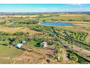 Stunning aerial view of a sprawling estate with a private lake and lush greenery at 10690 County Road One, Longmont, CO 80504