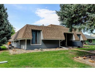 Unique two-story home with blue siding, brown roof, and well-manicured front lawn at 20 Scott Dr, Broomfield, CO 80020