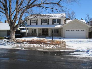 Charming two-story home with white brick and siding, complemented by black shutters and a well-maintained front yard at 1510 S Macon St, Aurora, CO 80012