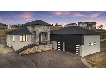 Stunning two-story home showcasing stone accents, a black roof, and an attached two-car garage at 10291 E 142Nd Ave, Brighton, CO 80602