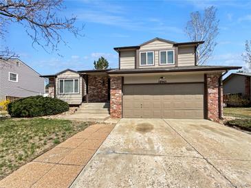 Charming two-story home featuring a brick and siding exterior with a two-car garage and manicured lawn at 18945 E 45Th Ave, Denver, CO 80249