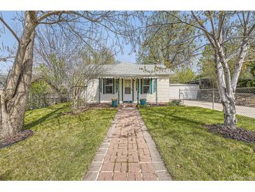 Charming home with well-manicured lawn, brick path, and cheerful green accents on the door and shutters at 5510 S Windermere St, Littleton, CO 80120