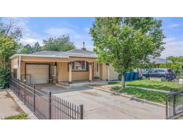 Charming single-story home with a covered porch, carport and black metal fence at 6871 Locust St, Commerce City, CO 80022
