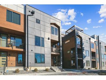 Modern townhome exterior showcasing mixed material facade, balconies, and landscaped entryways under a bright sky at 3017 W 53Rd Ave, Denver, CO 80221