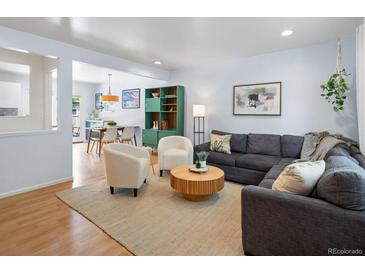 Inviting living room with hardwood floors, a comfortable sectional, and stylish decor creates a cozy atmosphere at 10109 W 68Th Ave, Arvada, CO 80004
