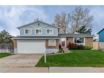 Charming two-story home with a well-maintained lawn and a two-car garage at 9340 W Burgundy Ave, Littleton, CO 80123