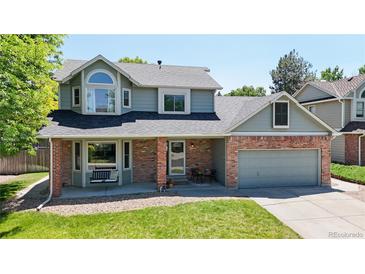 Charming two-story home with a well-manicured lawn and a cozy front porch seating area at 982 E 130Th Cir, Thornton, CO 80241