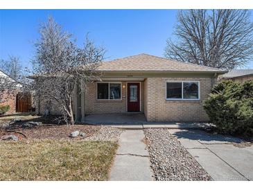 Charming single-story home with a brick facade, red door, landscaped yard, and a welcoming entrance at 1654 Valentia St, Denver, CO 80220