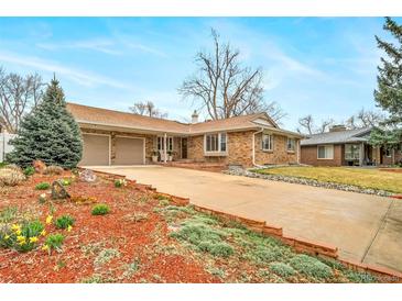 Charming brick home featuring an attached two-car garage and well-maintained landscaping at 2424 S Jasmine St, Denver, CO 80222