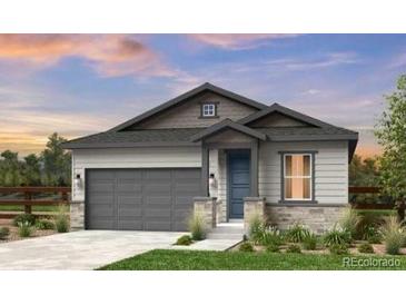 Charming single-story home featuring a two-car garage, complemented by a well-manicured lawn and inviting facade at 16975 W 92Nd Loop, Arvada, CO 80007