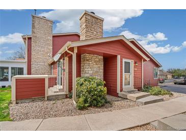 Charming red home with stone accents, landscaped front yard, and inviting entryway at 8424 Everett Way # A, Arvada, CO 80005