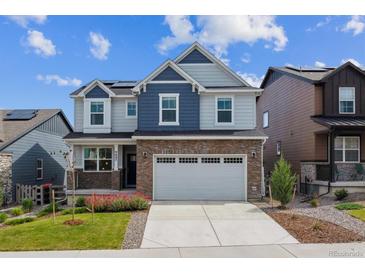 Charming two-story home featuring a brick front, white garage door, and a landscaped yard at 9807 Rosalee Peak St, Littleton, CO 80125
