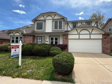 Charming two-story home featuring a two-car garage, brick accents and well-manicured front lawn at 8182 Sweet Water Rd, Lone Tree, CO 80124
