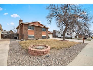 Well maintained brick two-story home featuring a cozy firepit and gravel landscaping at 838 S 10Th Ave, Brighton, CO 80601