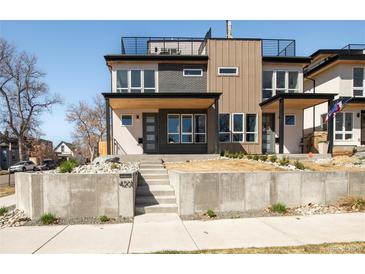 Modern home with a rooftop deck, brick accents, and a well-manicured front yard and walkway to the entrance at 4201 Vallejo St, Denver, CO 80211
