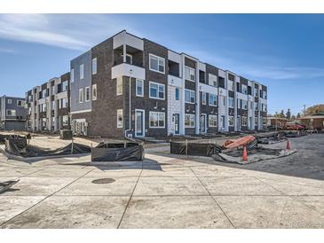Modern townhome featuring stylish brick and siding, set against a clear blue sky at 370 N. Geneva St, Aurora, CO 80010