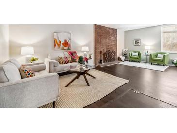 Bright living room featuring a brick fireplace, hardwood floors, and contemporary furnishings at 3339 S Monaco Pkwy # A, Denver, CO 80222
