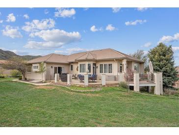 An alluring outdoor living space showcases a spacious deck and lush lawn, perfect for relaxation and entertainment at 11064 Hermitage Run, Littleton, CO 80125