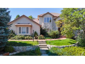Charming home featuring manicured lawn, stone accents and mature trees at 1977 Champions Cir, Castle Rock, CO 80104