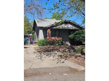 Charming single-story home featuring a brick porch and a well-maintained front yard with mature trees at 2117 S Lafayette St, Denver, CO 80210