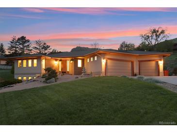 Stunning home with a three-car garage, beautiful landscaping, and a lush green lawn at 4305 Easley Rd, Golden, CO 80403