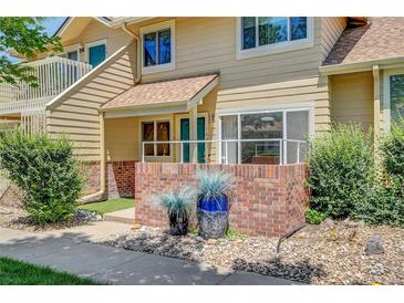 Inviting townhome with a charming brick facade and well-maintained landscaping at 2181 S Troy Way # 103, Aurora, CO 80014