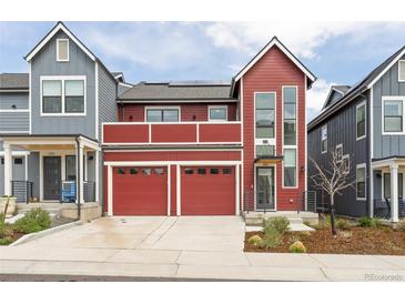 Beautiful two-story red home with a two-car garage and second story deck at 285 Clementina St, Louisville, CO 80027