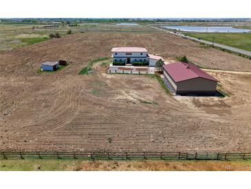Expansive aerial view of home, farm, and outbuildings on acreage with lake views in the distance at 3160 Bella Rosa Pkwy, Longmont, CO 80504