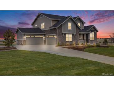 Stunning two-story home featuring a three-car garage, stone accents, and beautifully landscaped front yard at 8750 Red Primrose St, Franktown, CO 80116