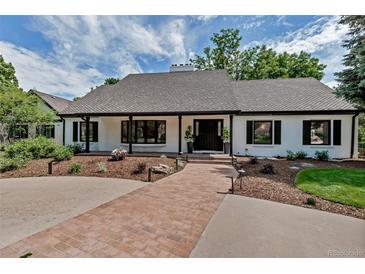 Charming single-story home with a brick pathway, lush landscaping, and black-trimmed windows at 17 E Belleview Ln, Greenwood Village, CO 80121