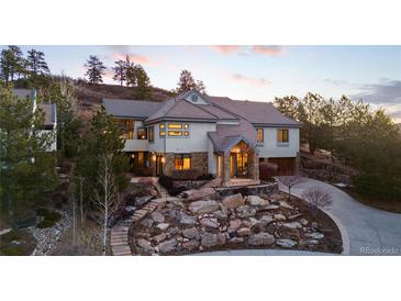 Stunning two-story home with stone landscaping and a charming covered front porch at 4788 Silver Pine Dr, Castle Rock, CO 80108
