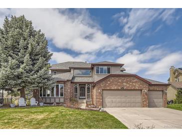 Charming two-story home with brick accents and well-manicured lawn at 6340 Ashburn Ln, Highlands Ranch, CO 80130