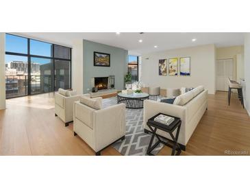 Inviting living room boasts a fireplace, city views from expansive windows, and neutral tones at 1777 Larimer St # 608, Denver, CO 80202