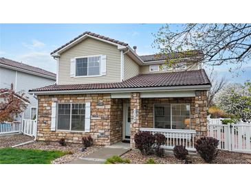 Charming two-story home featuring a stone facade, covered porch, and well-maintained landscaping at 11738 Zenobia Loop, Westminster, CO 80031