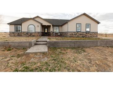 Charming ranch-style home featuring a stone facade and a well-maintained front yard at 16301 Hudson Rd, Hudson, CO 80642