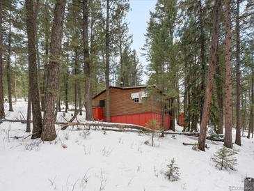 Cozy cabin nestled among towering pines and snow, offering privacy and seclusion at 5525 S Twin Spruce Dr, Evergreen, CO 80439