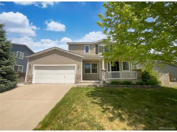 Charming two-story home with a well-manicured lawn, attached garage, and inviting front porch at 12550 Eastlake Dr, Thornton, CO 80241