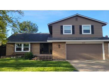 Charming two-story home featuring a brick and painted facade, attached garage, and well-maintained front lawn at 8268 W Caley Pl, Littleton, CO 80123