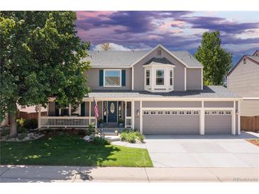 Charming two-story home with a three-car garage, well-manicured lawn, and welcoming front porch at 1774 Spring Water Pl, Highlands Ranch, CO 80129