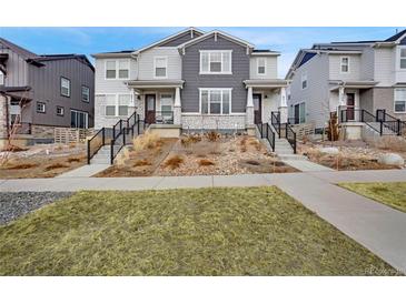 Charming townhouse with gray siding, stone accents, and well-maintained landscaping at 8211 Monte Vista Cir, Littleton, CO 80125