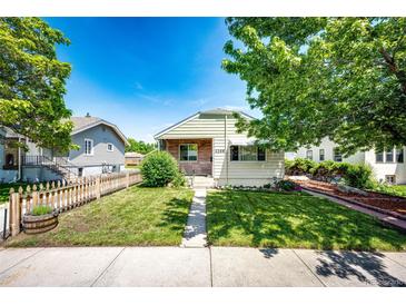 Charming home featuring a well-maintained front yard with a classic picket fence and blue skies at 2268 Jay St, Edgewater, CO 80214