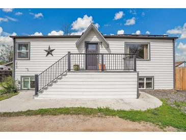 Charming home with a white exterior, black trim, and a welcoming front porch with stairs at 215 Jay St, Lakewood, CO 80226