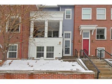 Charming townhome featuring brick and siding exterior, front porch, and well-maintained landscaping during winter season at 3401 N Xenia St, Denver, CO 80238